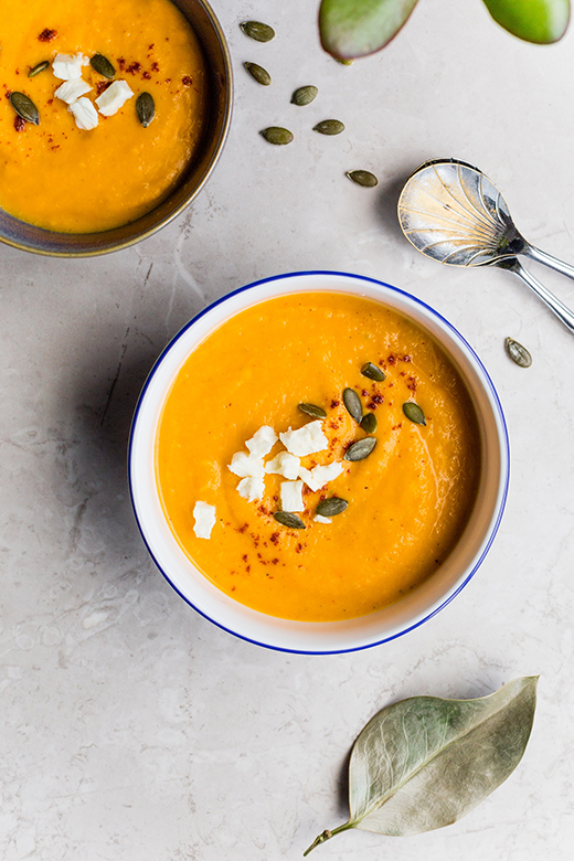 Butternut squash soup garnished with pumpkin seeds and cheese